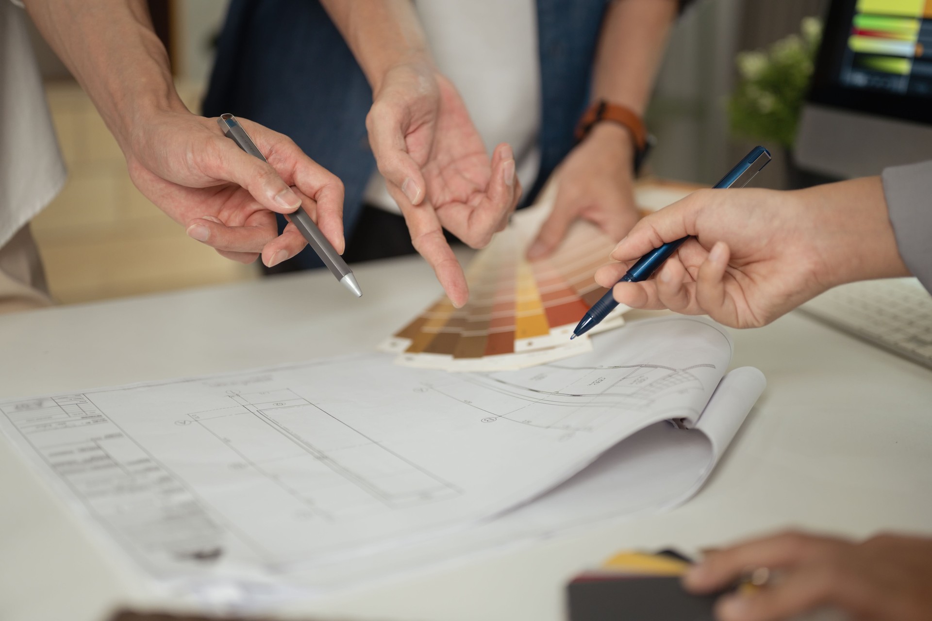 Interior designers choosing color paint and discussing design project at meeting table